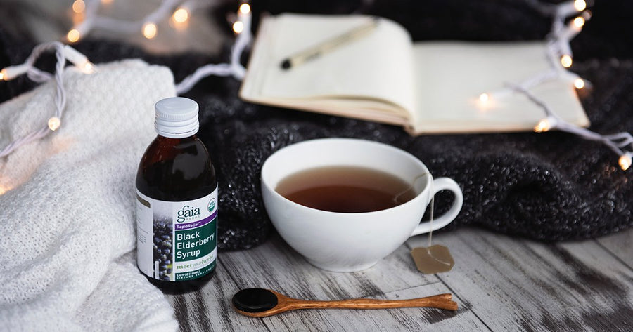 Gaia Herbs Black Elderberry Syrup next to mug of tea