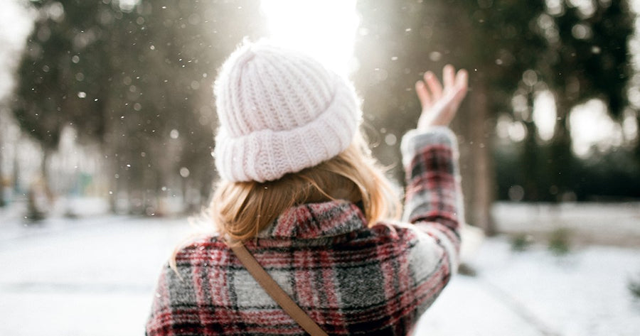 Woman in snow catching snowflakes