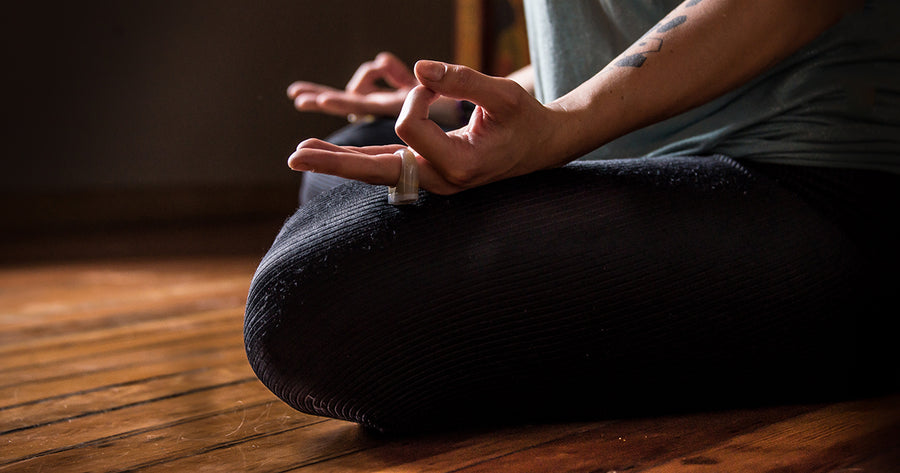 bottom half of woman meditating in lotus pose