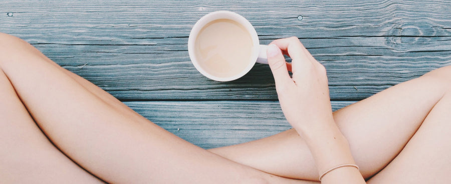 Woman sitting on hardwood with mug of coffee