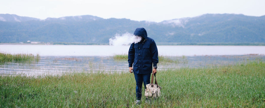 Man standing in field with cold air coming from his mouth