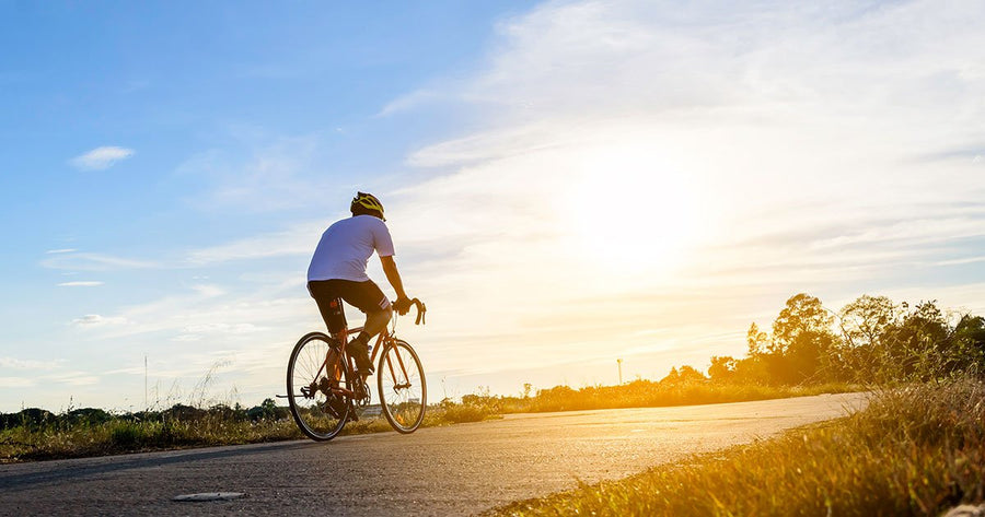 Man riding bike with bright sun background