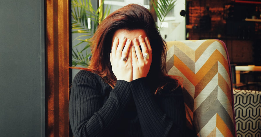 Woman covering her face because she is dealing with mental exhaustion