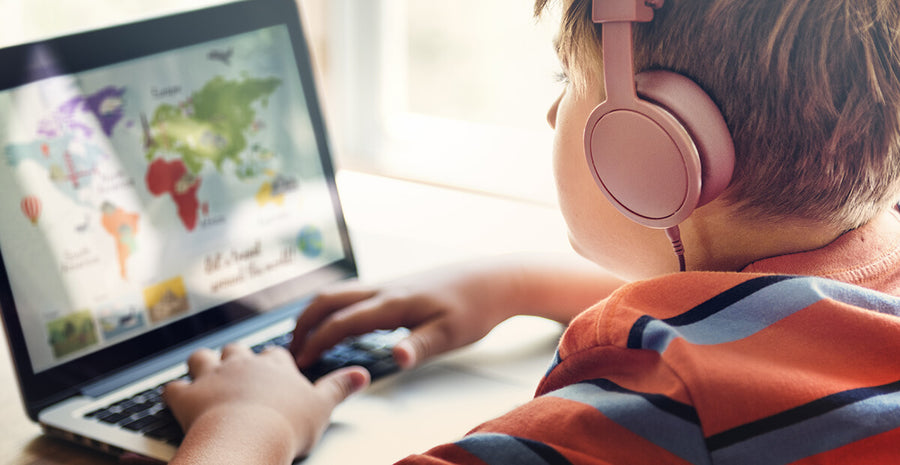 child with headphones on laptop