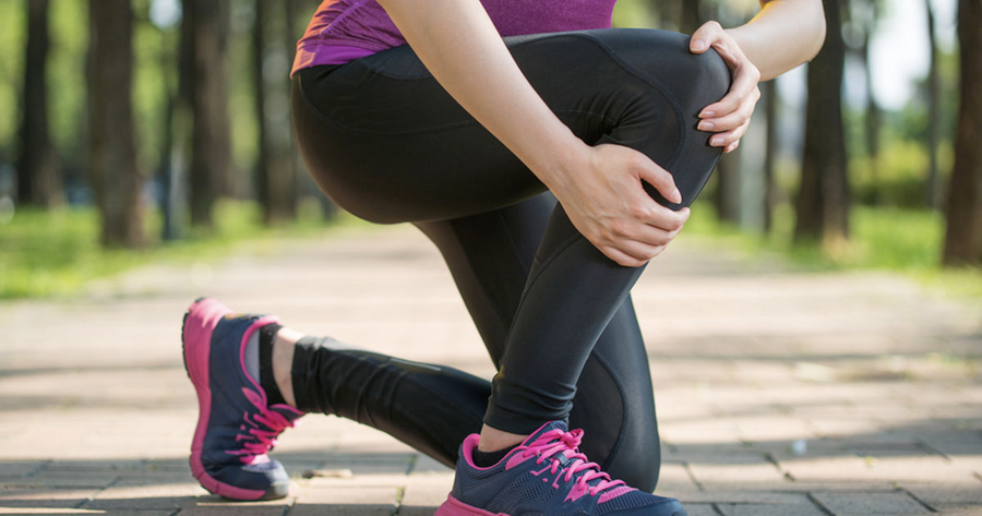 Woman holding her knee after running