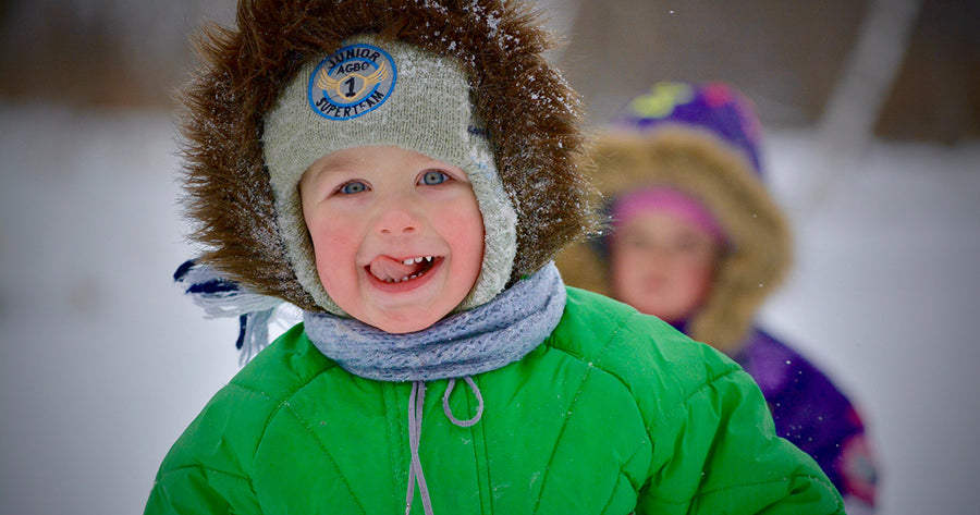 Children in snow bundled up in winter clothes 