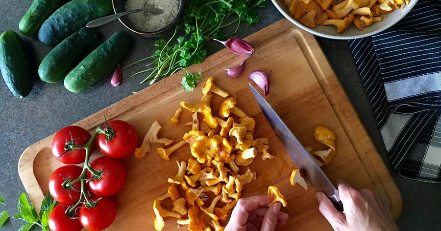 man cutting fresh vegetables on cutting board